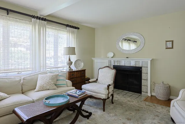 a living room with furniture a fireplace and a large window