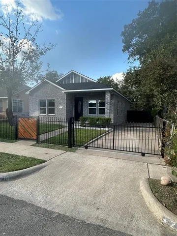a view of a house with a fence in front of house