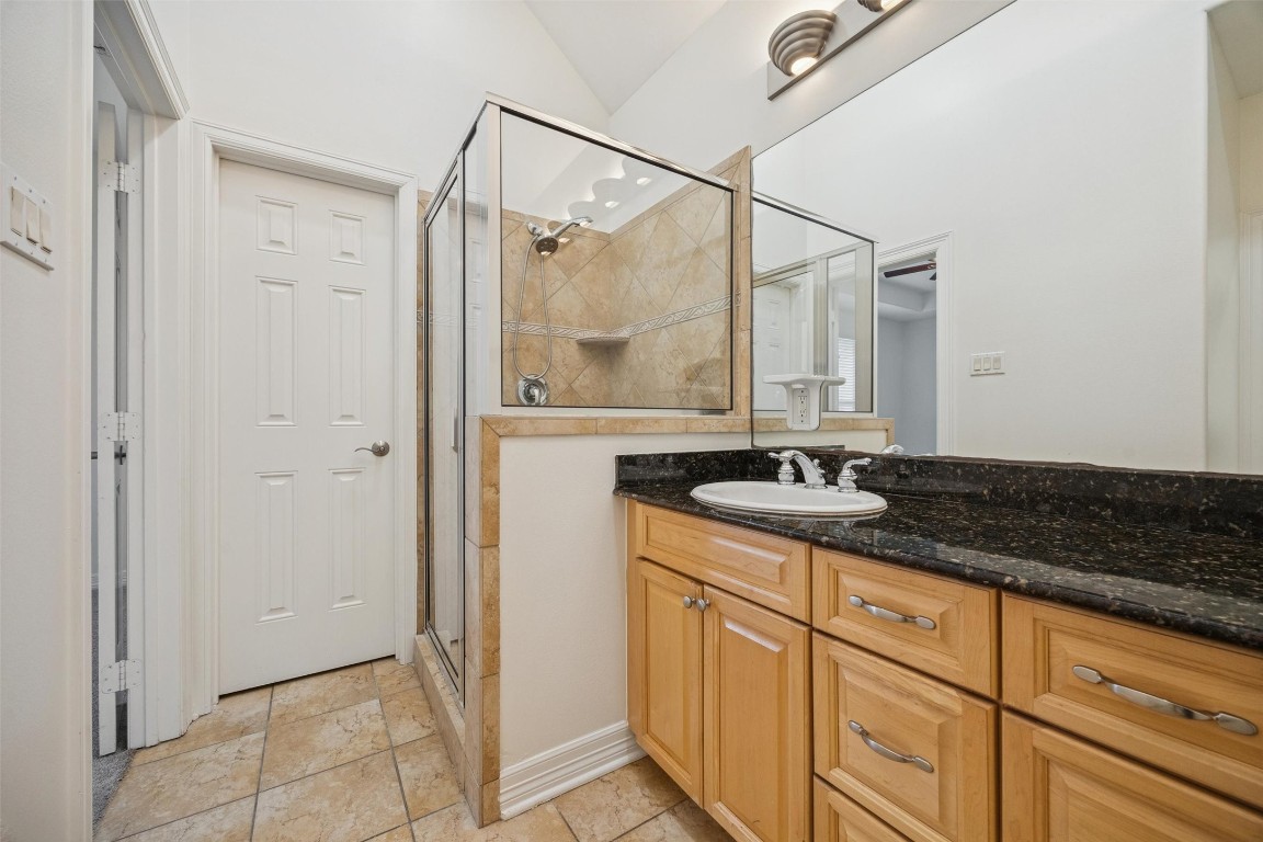 3322 Garden Crest Lane Houston, TX 77018 - Photo 18 of 31 The Primary bath also enjoys a glass-enclosed shower with tiled walls, a granite countertop and undermount sink and wooden cabinetry. The neutral tile flooring and bright lighting create a clean, modern look.