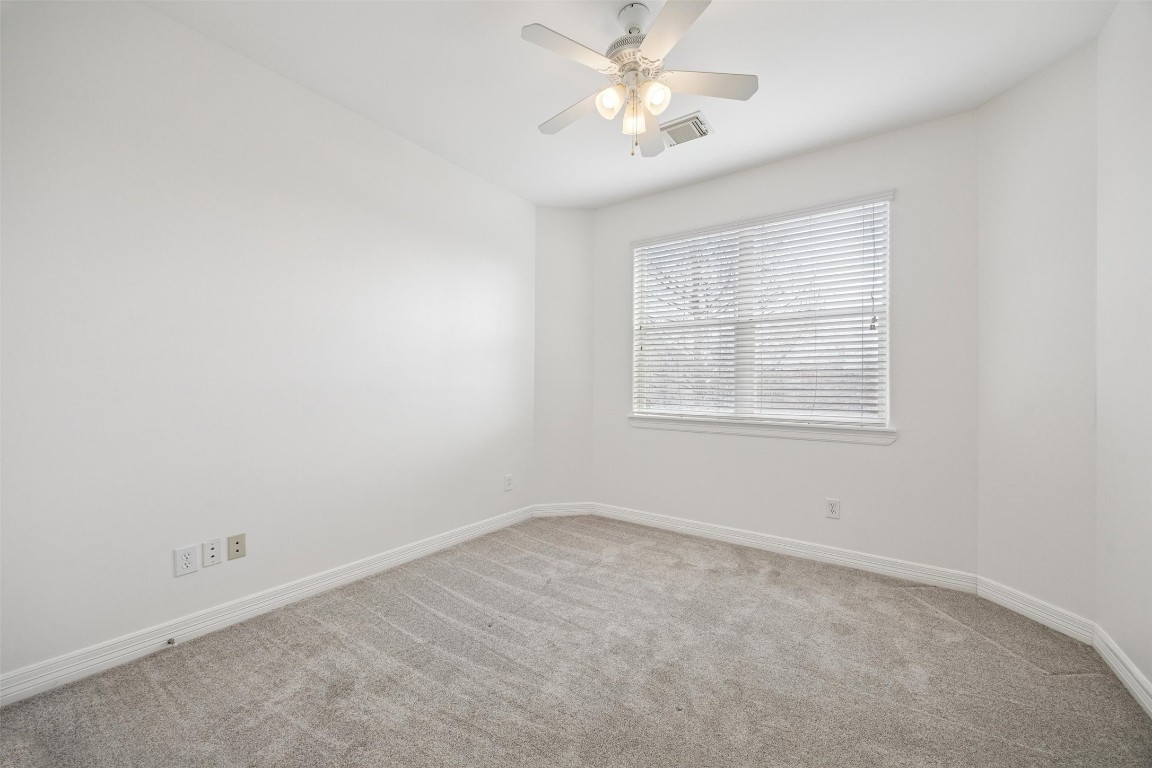 3322 Garden Crest Lane Houston, TX 77018 - Photo 20 of 31 This is a bright, cozy bedroom with neutral walls and carpet, featuring a ceiling fan and a large window with blinds.