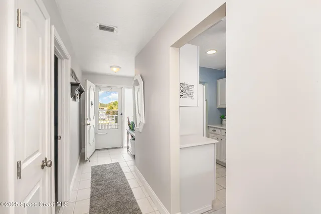 a view of a hallway with bathroom and wooden floor