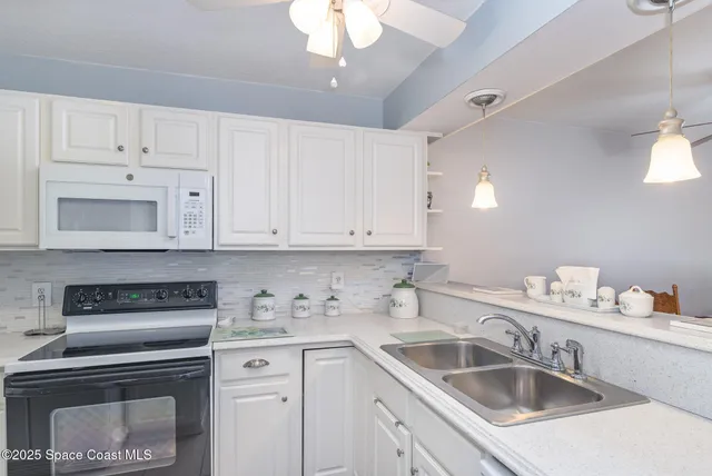 a kitchen with white cabinets a sink and dishwasher