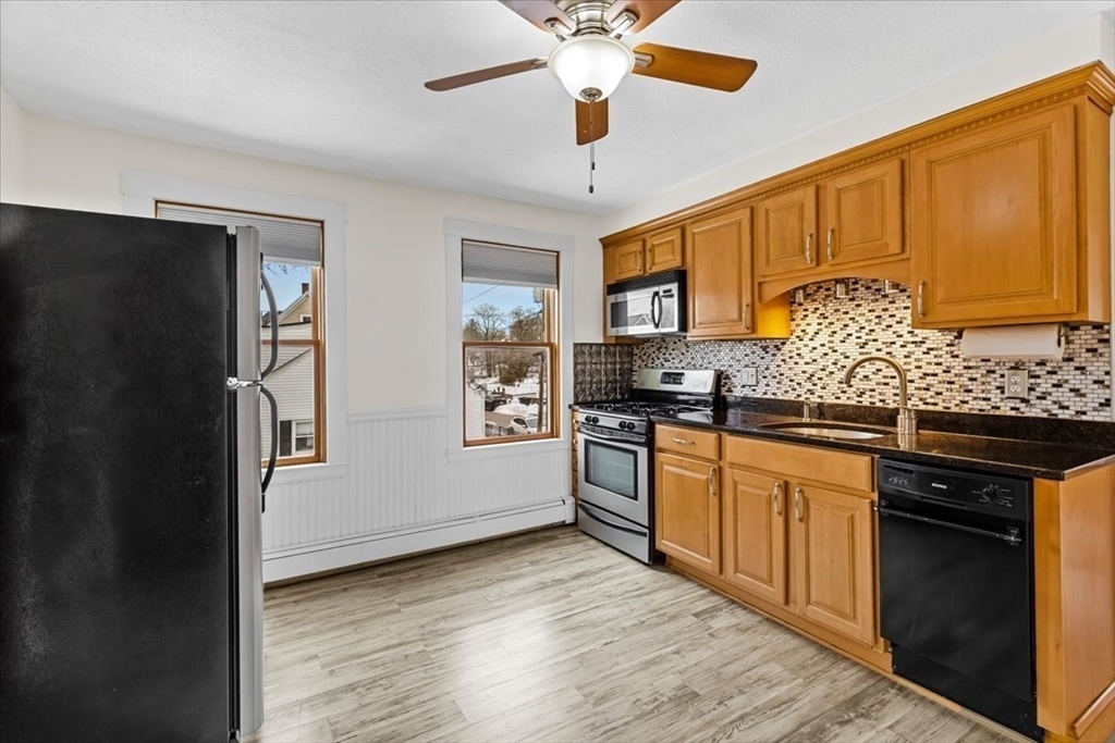 15 Hillock Street, Unit 2 Boston, MA 02131 - Photo 15 of 33 a kitchen with granite countertop stainless steel appliances and wooden cabinets