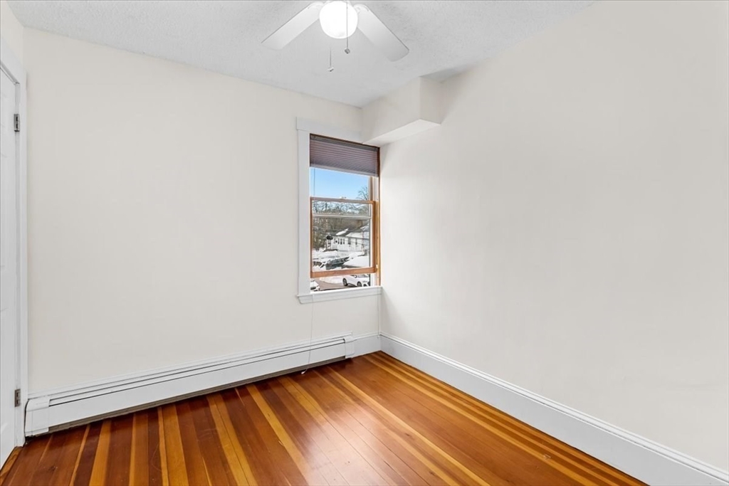 15 Hillock Street, Unit 2 Boston, MA 02131 - Photo 20 of 33 an empty room with wooden floor and windows
