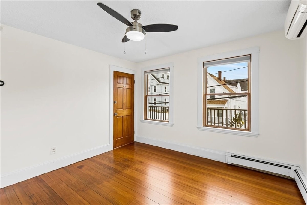 15 Hillock Street, Unit 2 Boston, MA 02131 - Photo 5 of 33 an empty room with wooden floor chandelier fan and windows