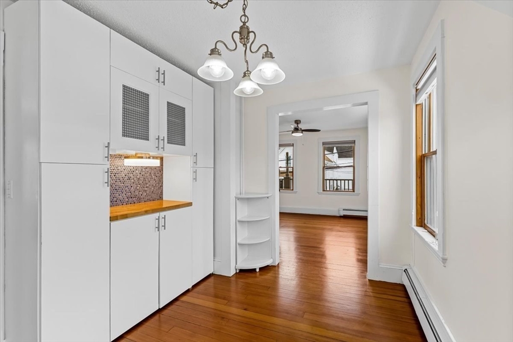 15 Hillock Street, Unit 2 Boston, MA 02131 - Photo 9 of 33 a view of a hallway with wooden floor and a kitchen