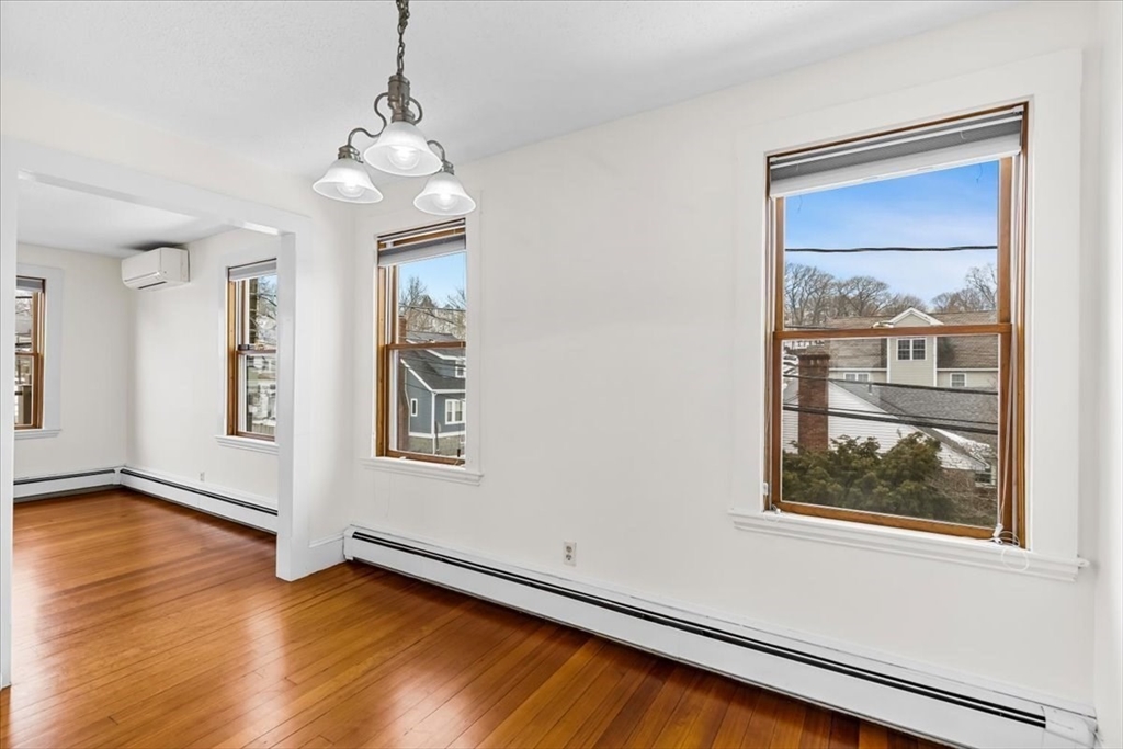 15 Hillock Street, Unit 2 Boston, MA 02131 - Photo 10 of 33 a view of an empty room with a window and wooden floor