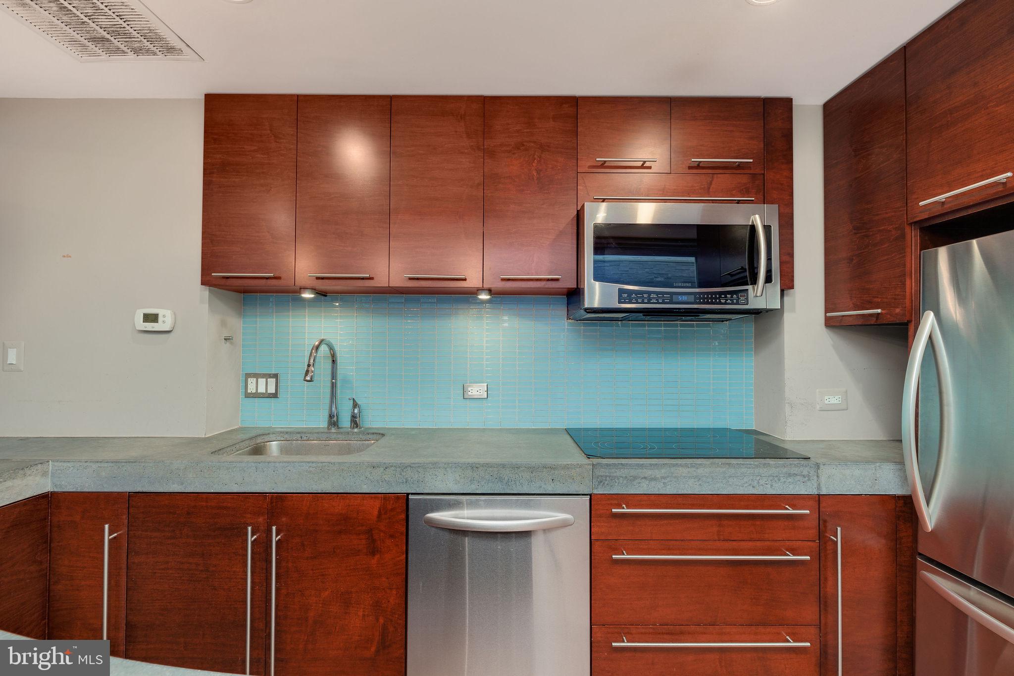 721 D Street Northeast Washington, DC 20002 - Photo 11 of 35 a kitchen with stainless steel appliances granite countertop a sink a stove and microwave