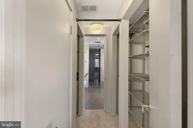 a view of a hallway with wooden shelves