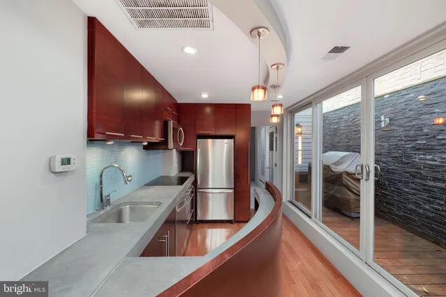 a kitchen with stainless steel appliances granite countertop a sink and a refrigerator
