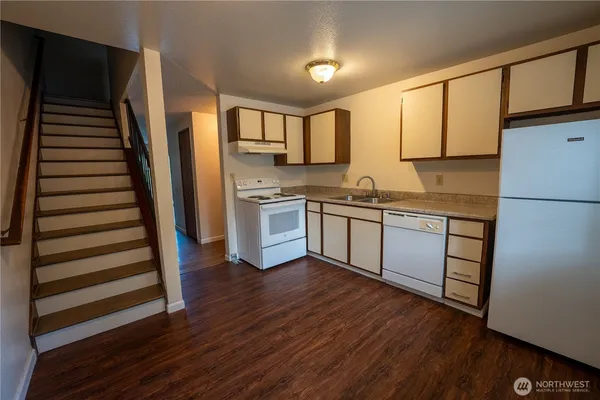 a kitchen with wooden floors and appliances