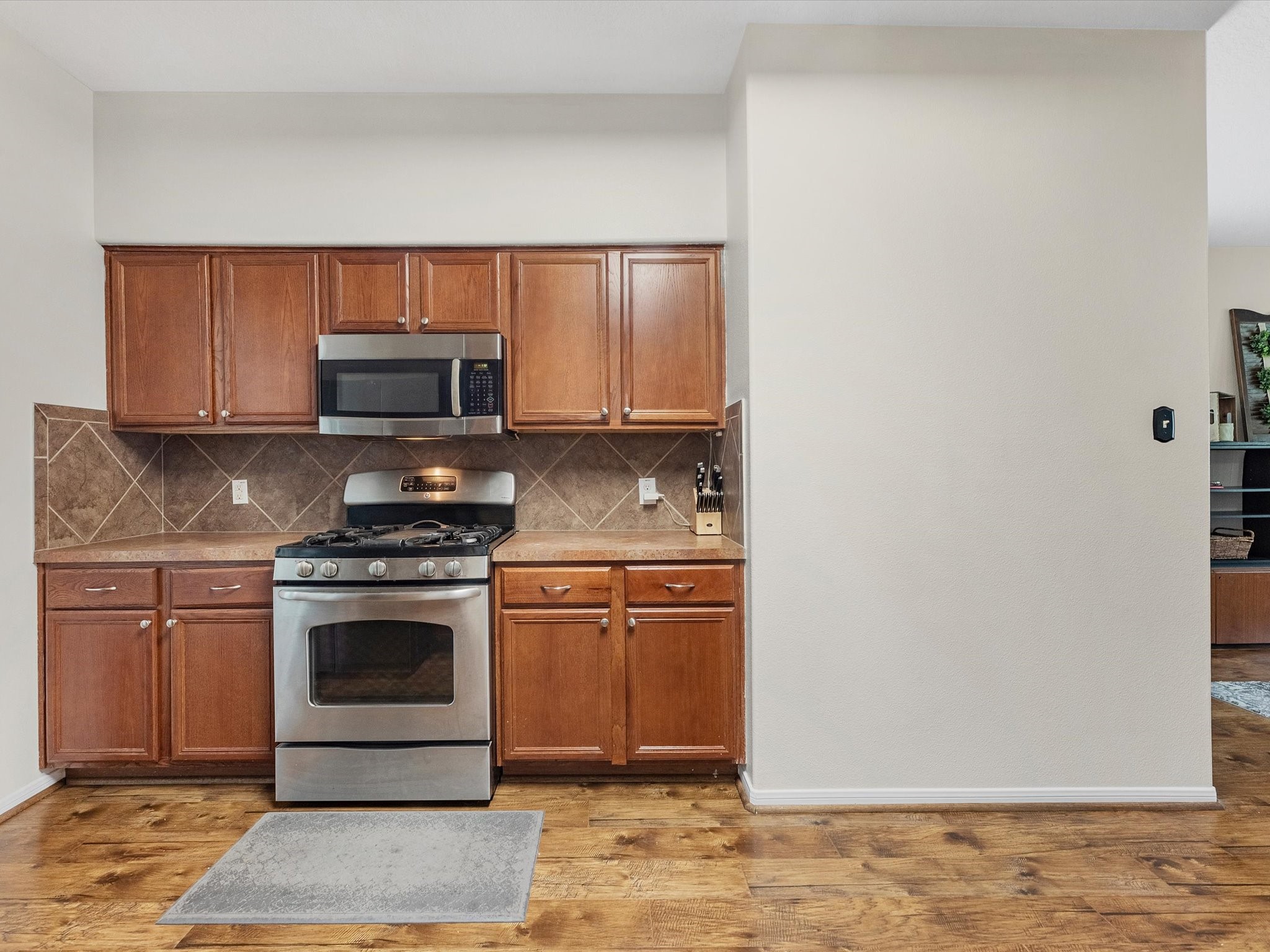 22422 Lamaster Lane Spring, TX 77373 - Photo 11 of 35 This kitchen features warm wood cabinets, a stainless steel oven and microwave, and tiled backsplash.