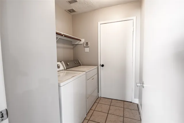 a utility room with cabinets washer and dryer