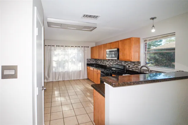 a kitchen with stainless steel appliances granite countertop a stove a sink and a refrigerator