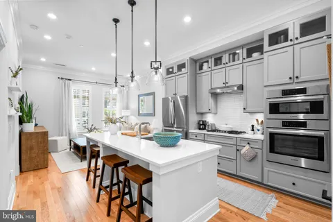 a kitchen with stainless steel appliances kitchen island granite countertop a stove a sink and a refrigerator