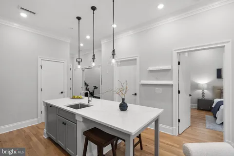 a kitchen with a sink a stove a refrigerator and white cabinets