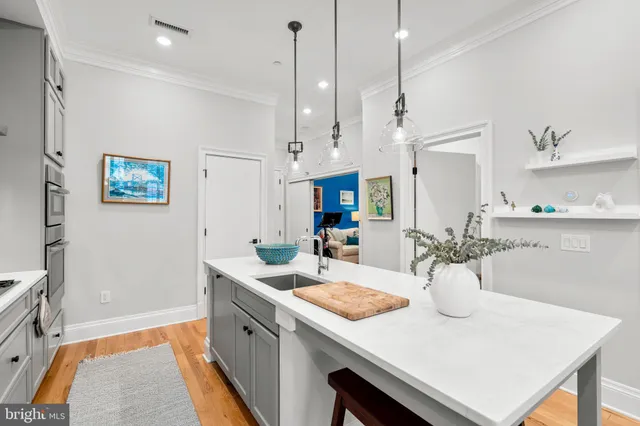 a kitchen with stainless steel appliances granite countertop a dining table chairs and refrigerator