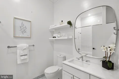 a bathroom with a sink a toilet and a mirror