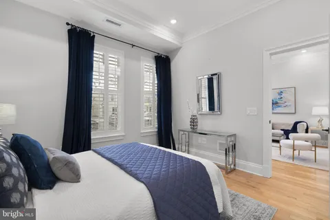 a bedroom with a large bed and wooden floor