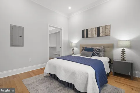 a bedroom with a bed and wooden floor