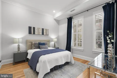 a bedroom with a bed and a large window