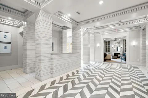 a view of a hallway with wooden floor and a bathroom
