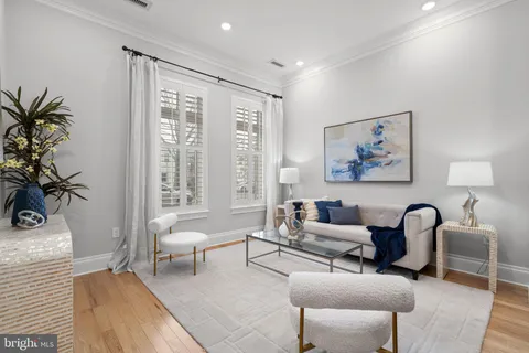 a living room with furniture and a large window with wooden floor