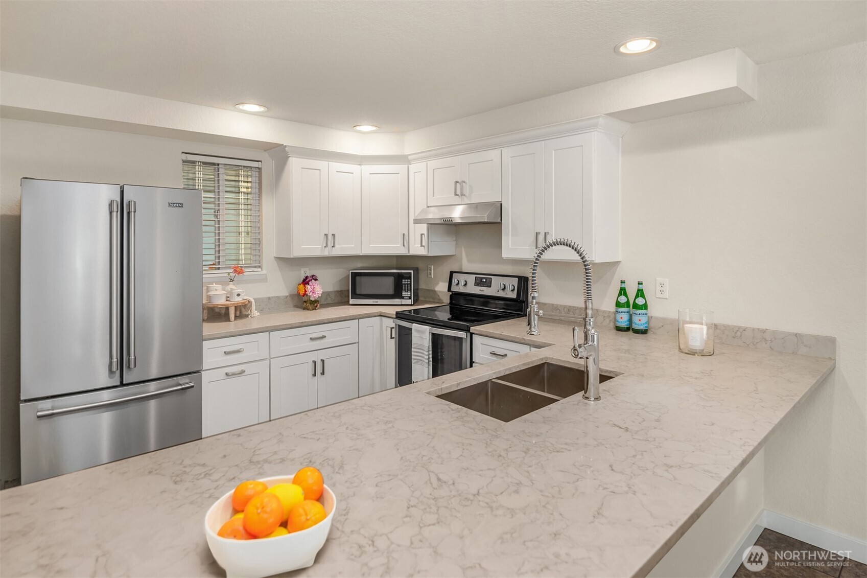12014 98th Avenue Northeast, Unit 101 Kirkland, WA 98034 - Photo 11 of 33 a kitchen with stainless steel appliances granite countertop a sink a stove a refrigerator a center island and cabinets