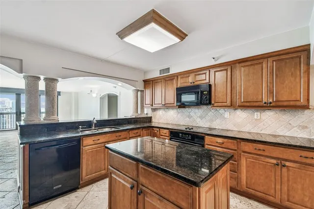 a kitchen with stainless steel appliances granite countertop a sink stove and microwave