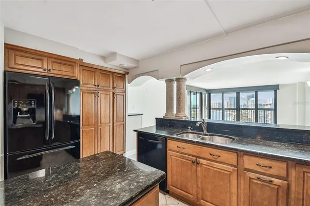 a kitchen with granite countertop a sink and a refrigerator