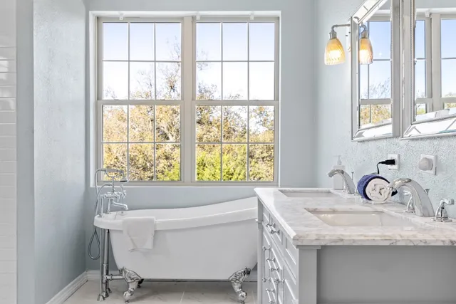 a bathroom with a granite countertop sink and a window