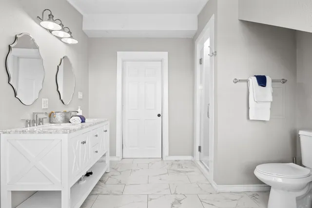 a bathroom with a sink a toilet and a mirror