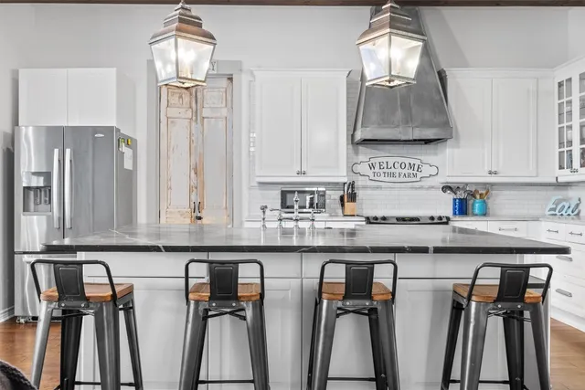 a kitchen with stainless steel appliances granite countertop a sink a stove and a wooden floors