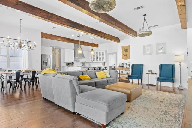 a living room with furniture a chandelier and a dining table