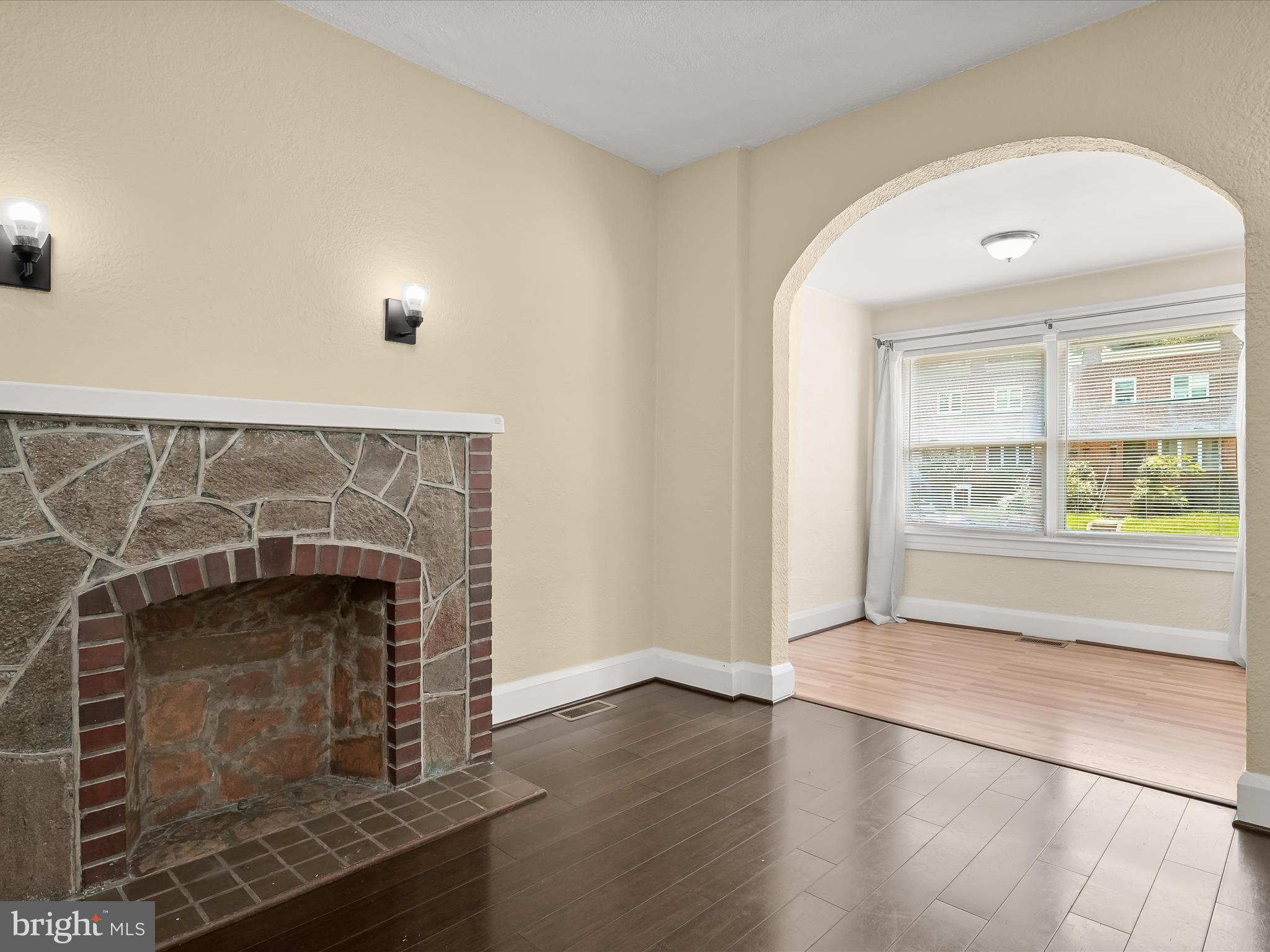 6204 Frederick Road Baltimore, MD 21228 - Photo 12 of 56 an empty room with wooden floor fireplace and windows