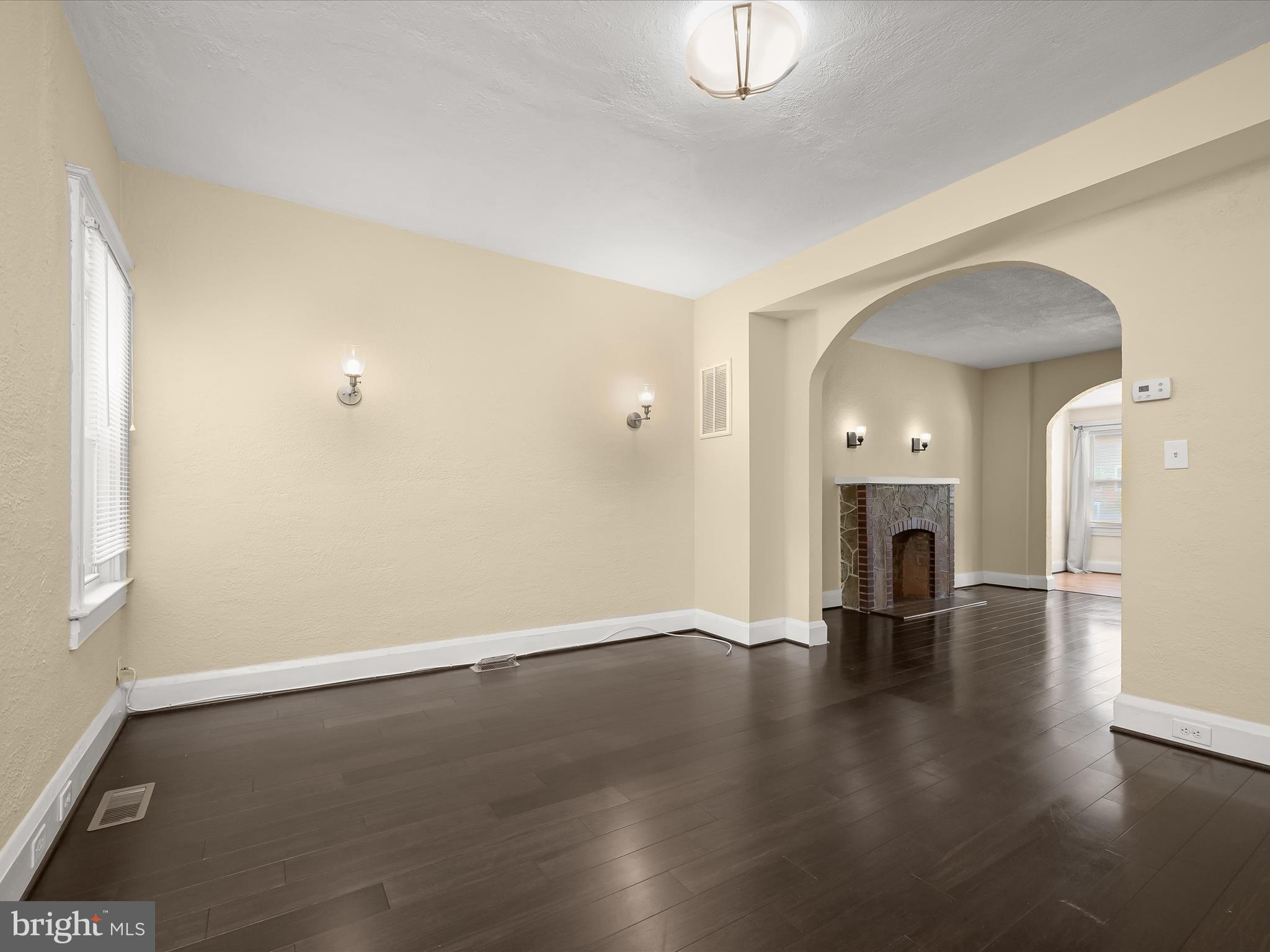 6204 Frederick Road Baltimore, MD 21228 - Photo 16 of 56 an empty room with wooden floor and fireplace