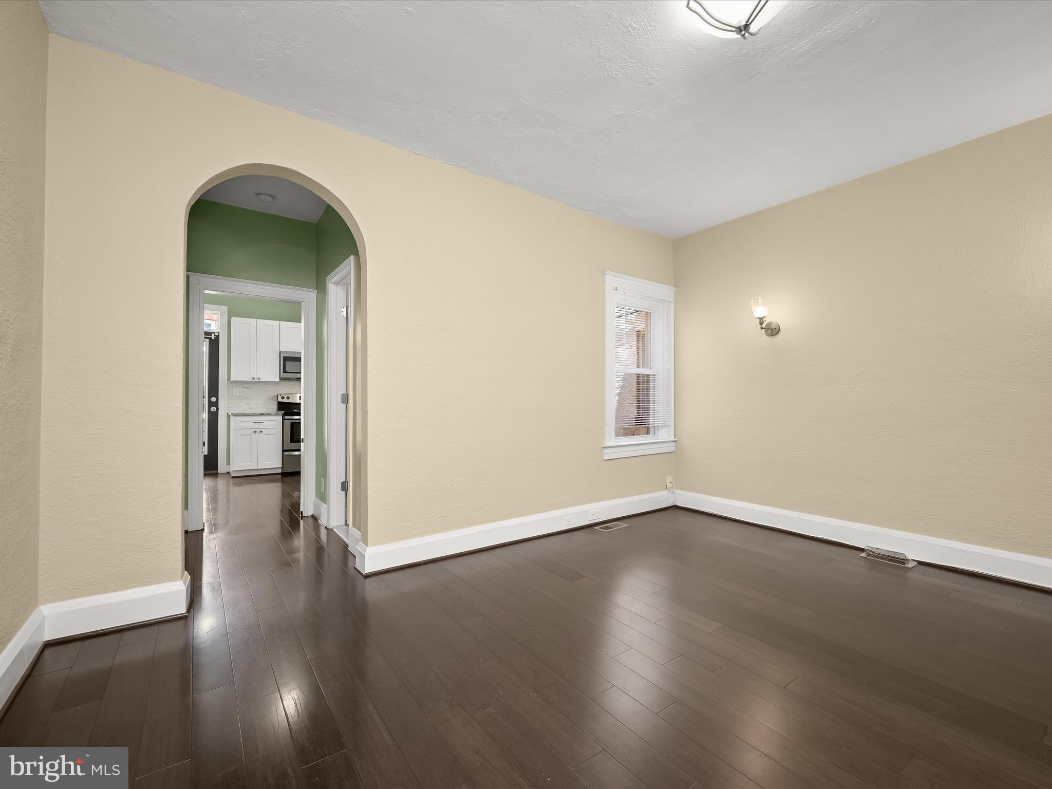 6204 Frederick Road Baltimore, MD 21228 - Photo 17 of 56 a view of an empty room with wooden floor and a window