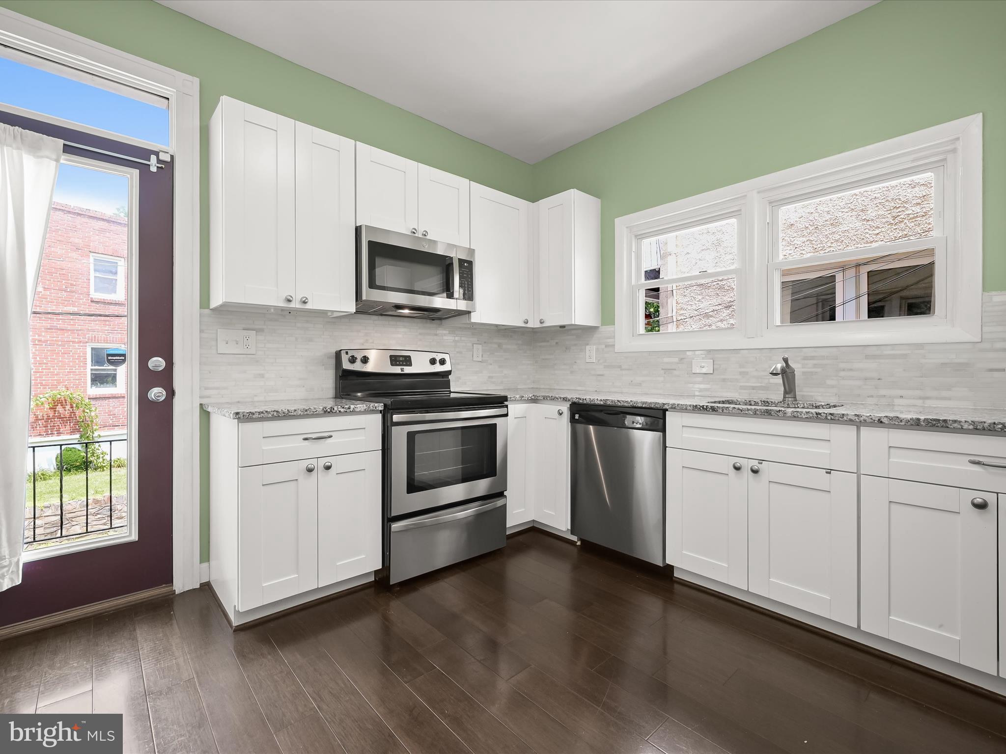 6204 Frederick Road Baltimore, MD 21228 - Photo 19 of 56 a kitchen with granite countertop white cabinets and stainless steel appliances
