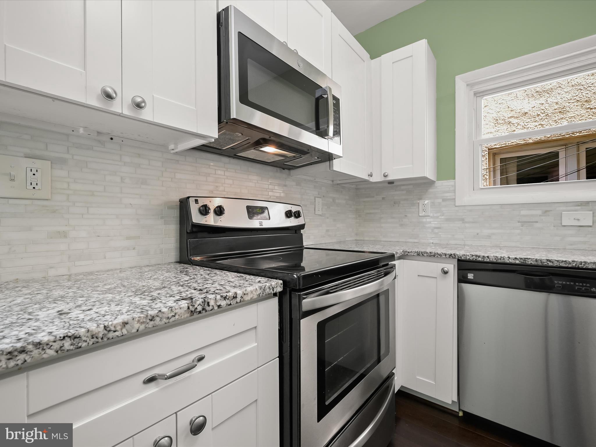 6204 Frederick Road Baltimore, MD 21228 - Photo 20 of 56 a kitchen with granite countertop cabinets stainless steel appliances and wooden floor