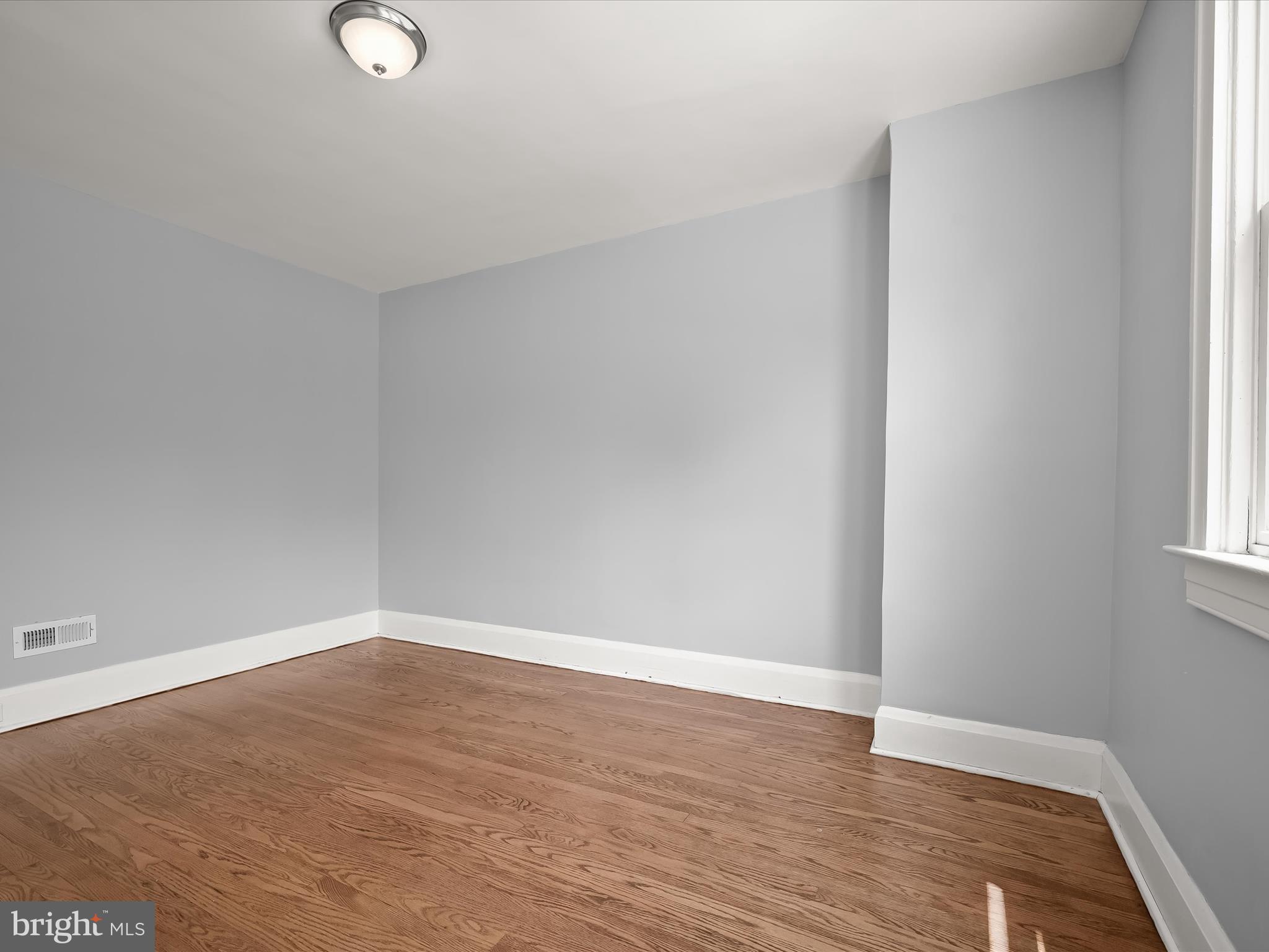 6204 Frederick Road Baltimore, MD 21228 - Photo 26 of 56 a view of an empty room with wooden floor and a window