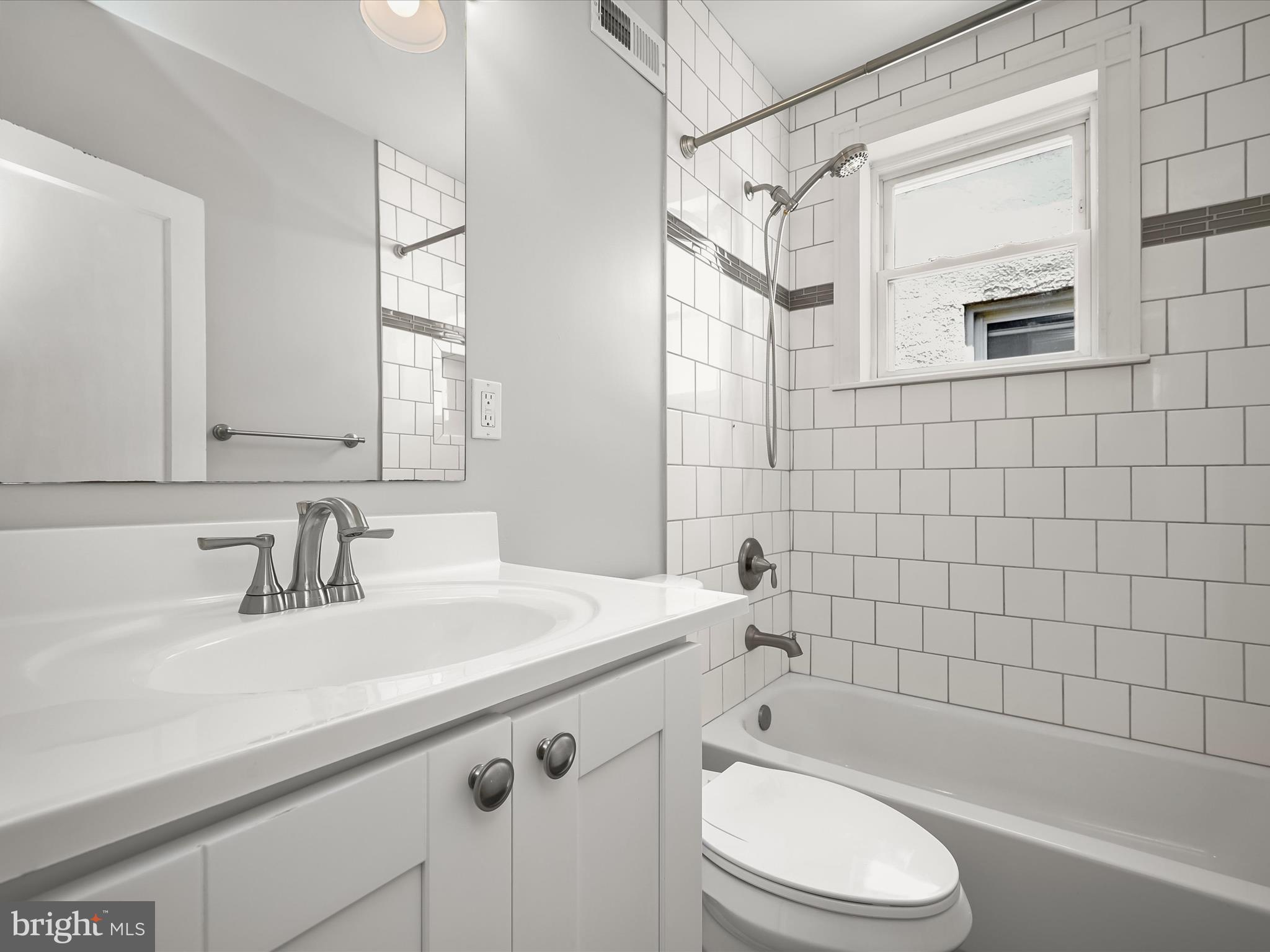 6204 Frederick Road Baltimore, MD 21228 - Photo 28 of 56 a bathroom with a sink a toilet and shower