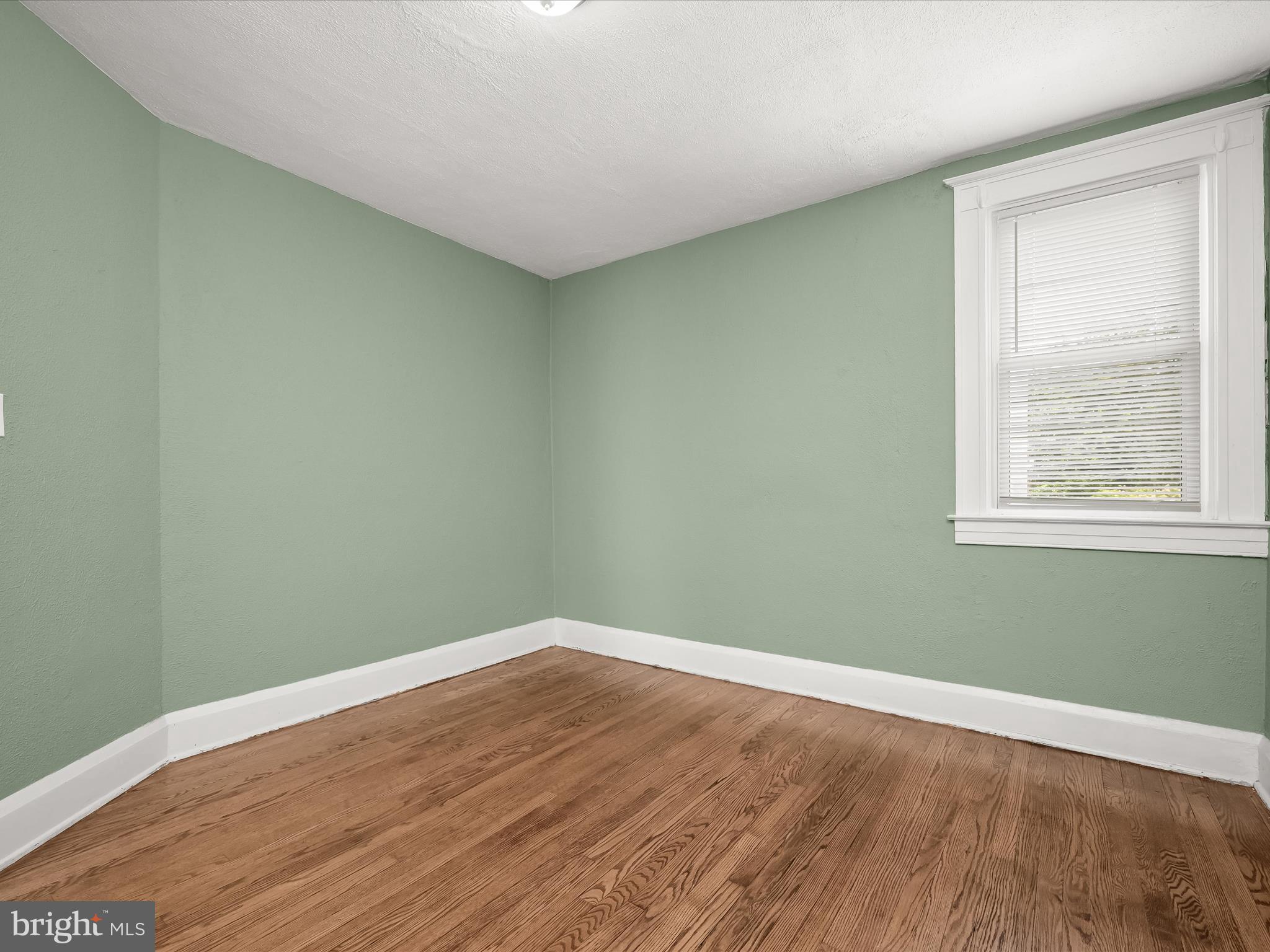6204 Frederick Road Baltimore, MD 21228 - Photo 31 of 56 an empty room with wooden floor and windows