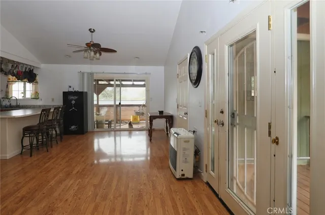 a view of a hallway with wooden floor and a dining room