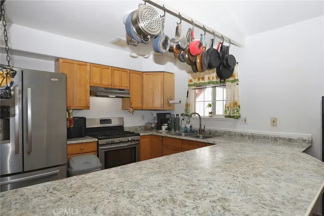 a kitchen with granite countertop a sink cabinets and stainless steel appliances