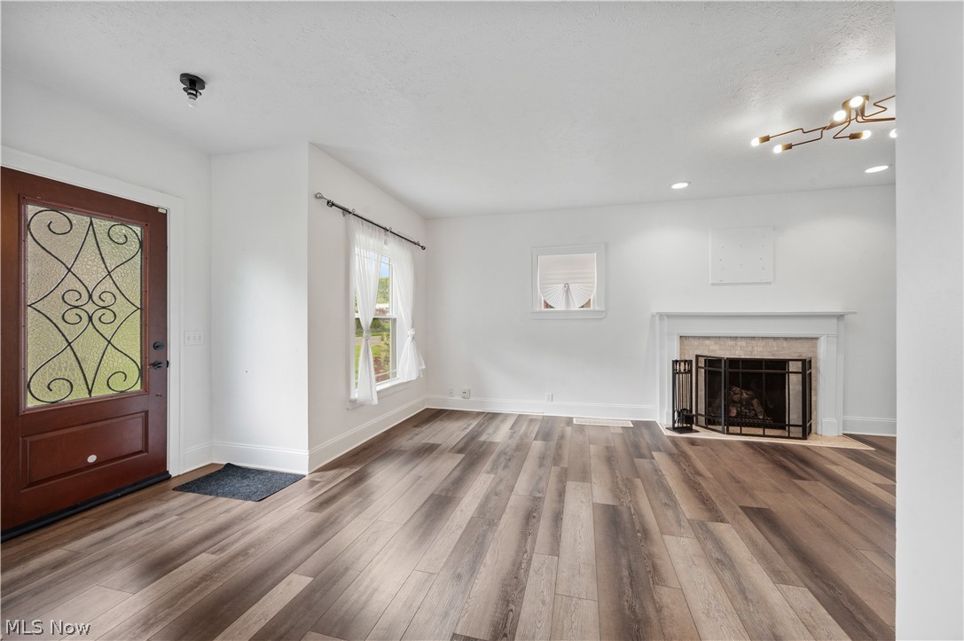 371 Merriman Road Akron, OH 44303 - Photo 3 of 27 Spacious room featuring wood-finish flooring, a decorative fireplace with a tile surround and mantel, recessed lighting, and a modern ceiling fixture