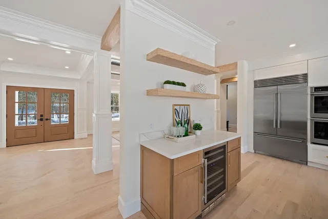 a kitchen with kitchen island white cabinets and refrigerator