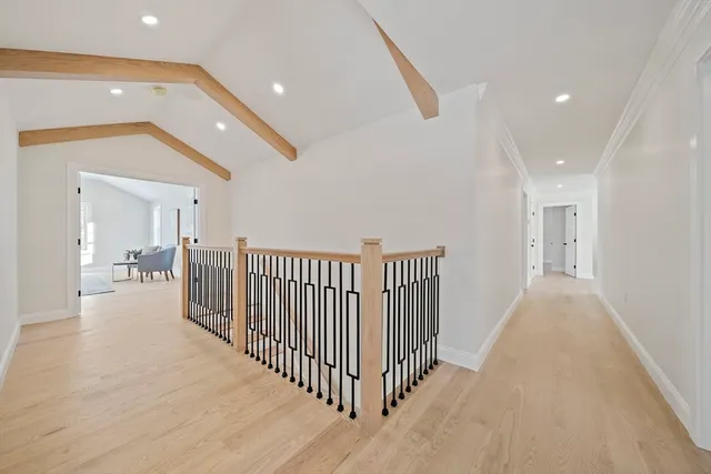 a view of a hallway with wooden floor and windows