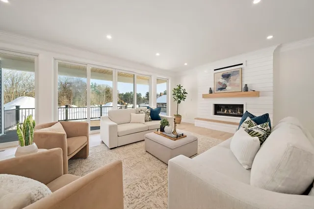 a living room with furniture large window and a fireplace