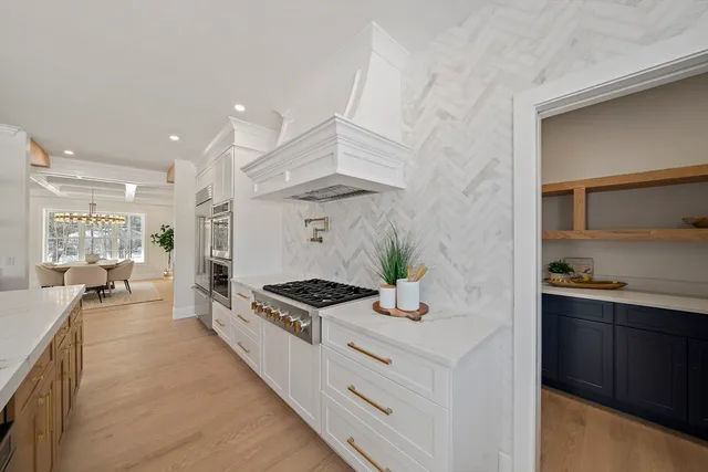 a kitchen with stainless steel appliances kitchen island granite countertop a stove a sink and a refrigerator