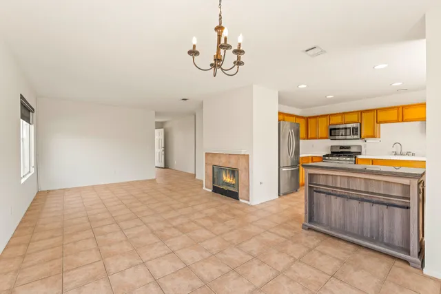 a kitchen with stainless steel appliances granite countertop a refrigerator a oven a sink and a chandelier